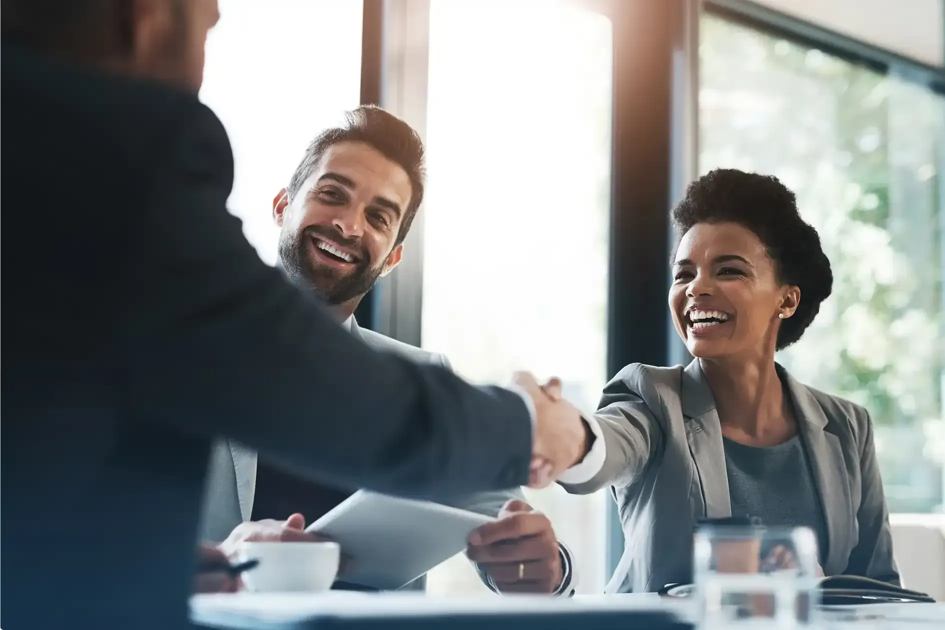 Two ACWA members shaking hands across a meeting table